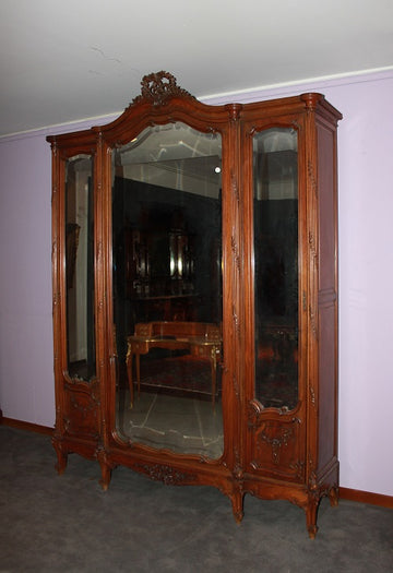 Large French Louis Philippe style 3-door mirrored wardrobe from the 1800s with rich carving motifs