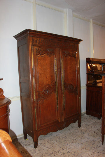 French Normandy wardrobe from the late 1700s with 2 richly carved doors in oak wood