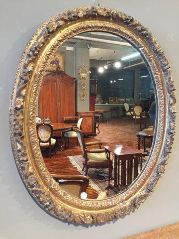 Antica specchiera ovale italiana del 1700 in legno dorato intagliato