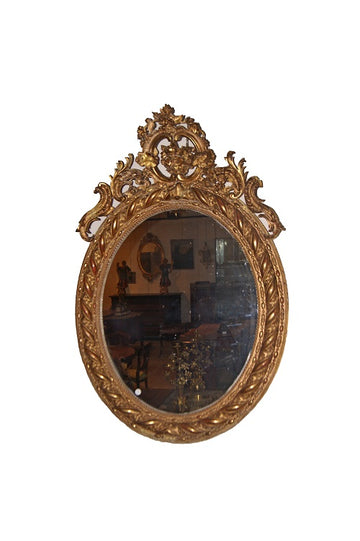 Large French vertical oval mirror from the 19th century, richly finished with a beautiful cymatium