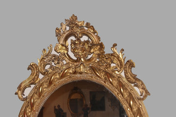 Large French vertical oval mirror from the 19th century, richly finished with a beautiful cymatium