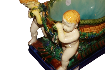 Centrotavola in ceramica di Caltagirone con putti e decorazione floreale