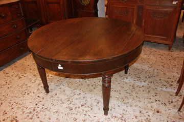 Large circular extendable table from the early 19th century in walnut wood