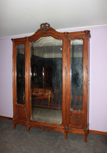 Large French Louis Philippe style 3-door mirrored wardrobe from the 1800s with rich carving motifs