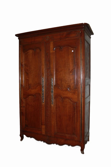 Armoire provençale du début du 19ème siècle en merisier à motifs sculptés