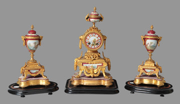 Antique French triptych consisting of a mantel clock and two porcelain vases