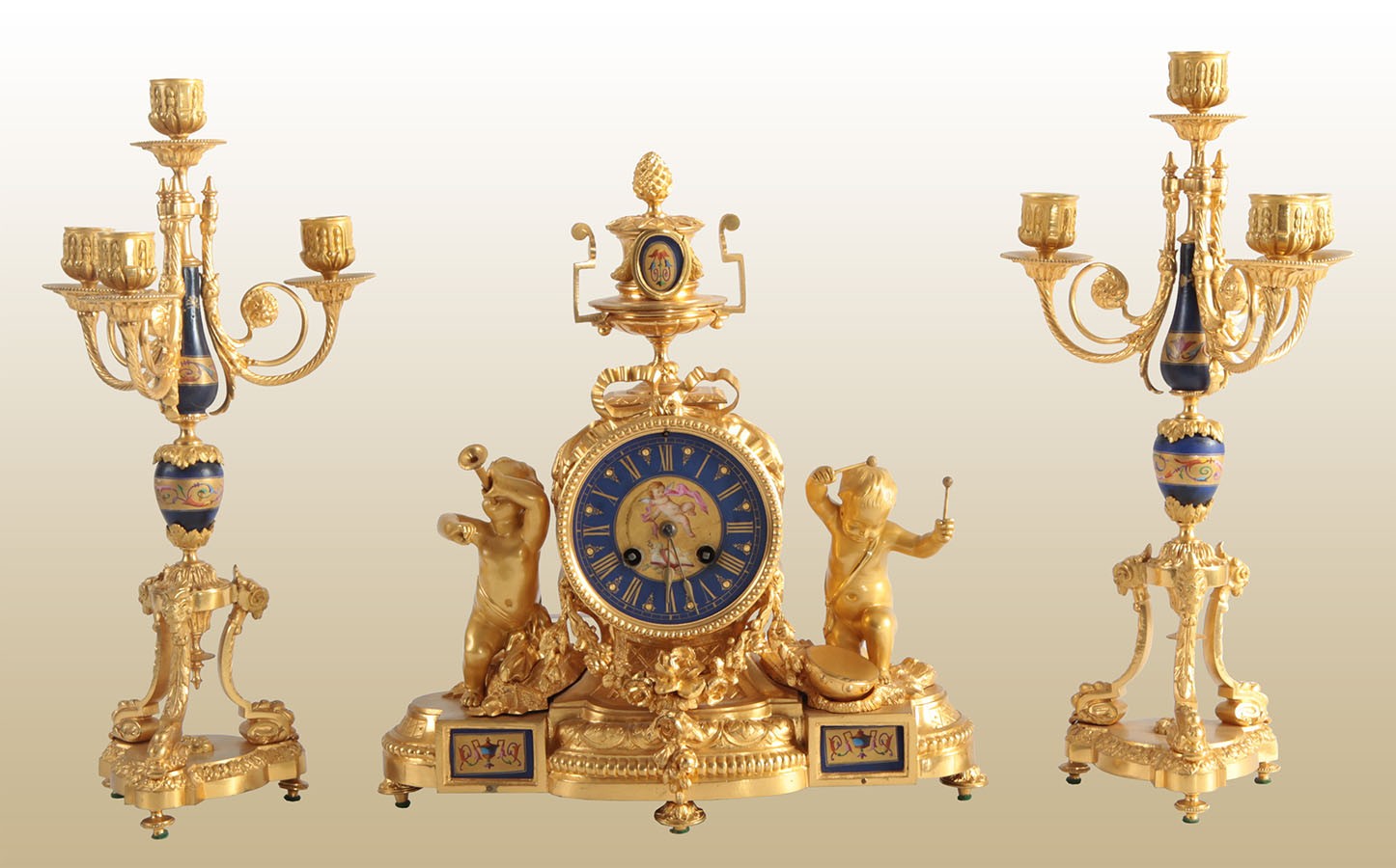 Tris orologio e candelieri in bronzo dorato
