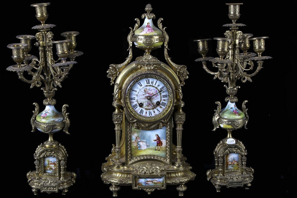 Tris composto da orologio,due candelabri a 5 fiamme in metallo meccato