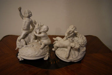 Paire de figurines en biscuit représentant des animaux et des chérubins